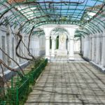a walkway in a building with green railings
