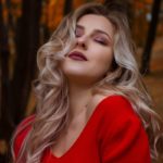 woman in red knit V-neck shirt in forest