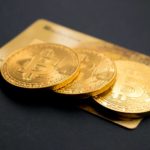 three round gold-colored Bitcoin tokens