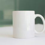 a white coffee mug sitting on top of a table